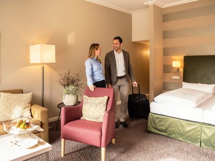 Traben-Trarbach, Hotel Moselschlösschen © Mosellandtouristik GmbH/Dominik Ketz Ansicht auf ein Paar in einem Hotelzimmer des Hotels Moselschlösschen in Traben-Trarbach.