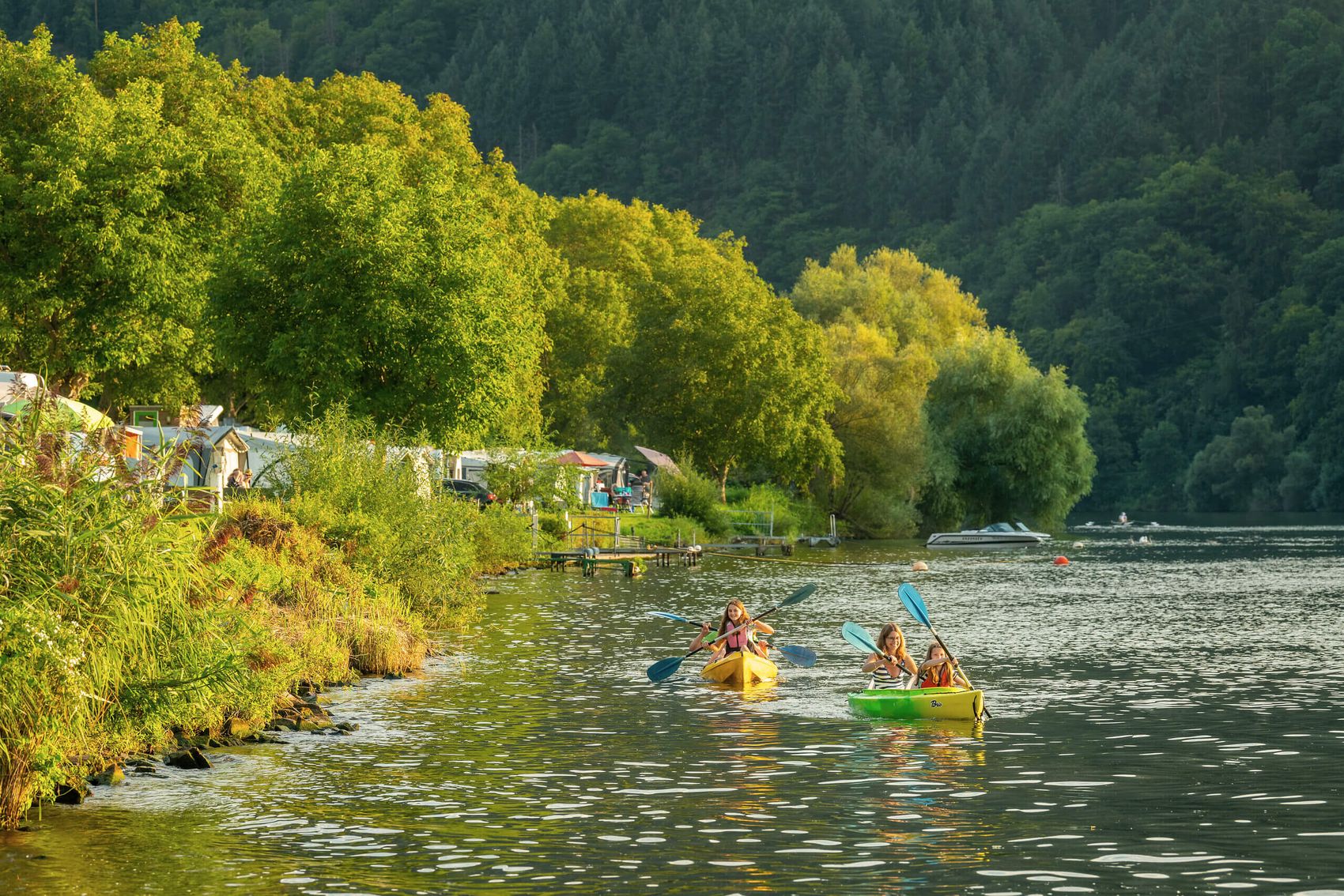 Kanufahrt auf der Mosel mit Einstieg vom Campingplatz © D. Ketz/Mosellandtouristik GmbH Familie in zwei gelbgrünen Kanus auf dem Fluss in Ufernähe