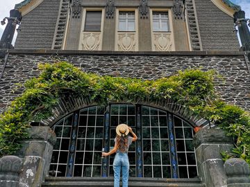 Ansicht auf eine Frau mit Hut vor der Villa Huesgen in Traben-Trarbach