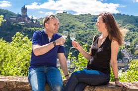 Lachendes Pärchen mit Wein vor Reichsburg Cochem