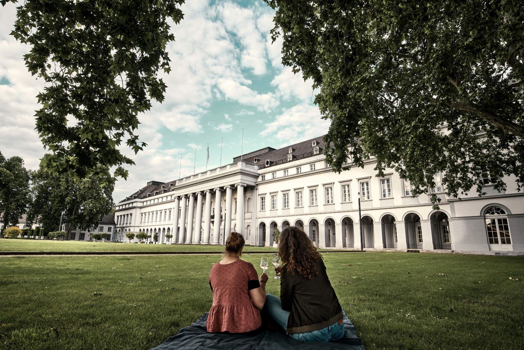 Koblenz, Kurfürstliches Schloss © Koblenz-Touristik GmbH / Brüderle Ansicht auf zwei Frauen, die vor dem Kurfürstlichen Schloss ein Glas Wein trinken.