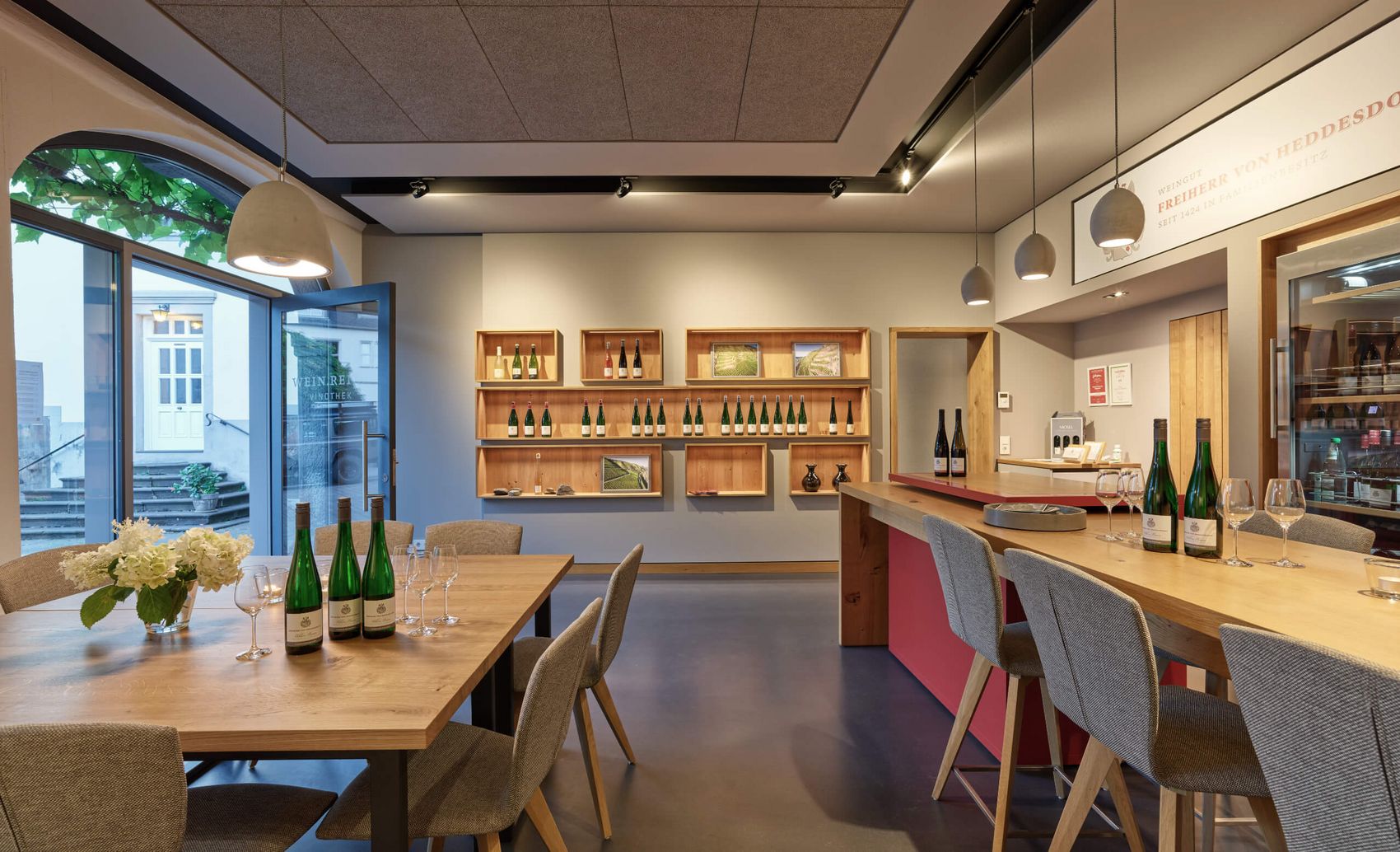 Winningen, Vinothek des Weingut Freiherr von Heddesdorff © Weingut Freiherr von Heddesdorff Theken- und Sitzbereich einer Vinothek mit modernem Holzinterieur