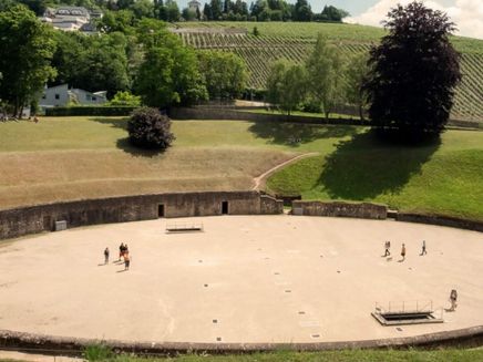 Trier, Amphitheater © Trier Tourismus & Marketing GmbH Eine Frau im Sommerkleid betrachtet das Amphitheater in Trier.