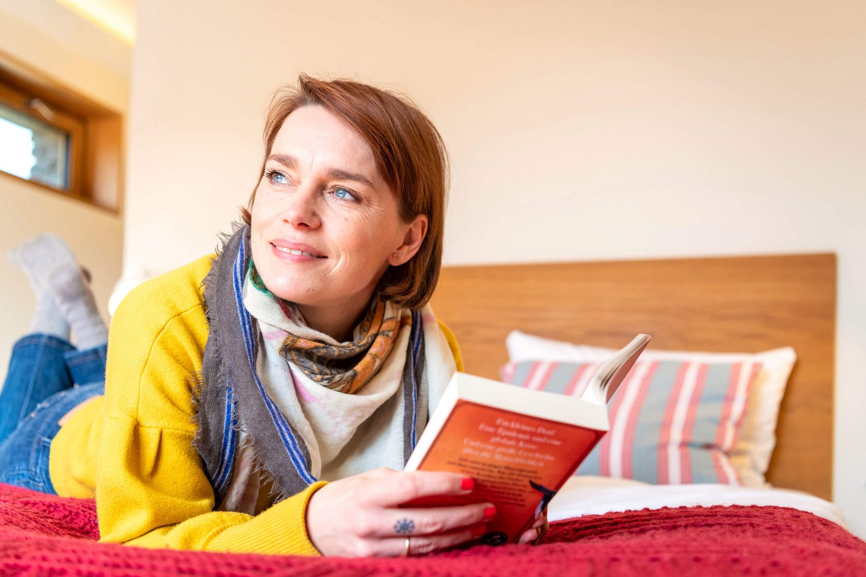 Buch lesen © Mosellandtouristik GmbH/Dominik Ketz Ansicht auf eine Frau, die auf einem Bett liegt und ein Buch liest.