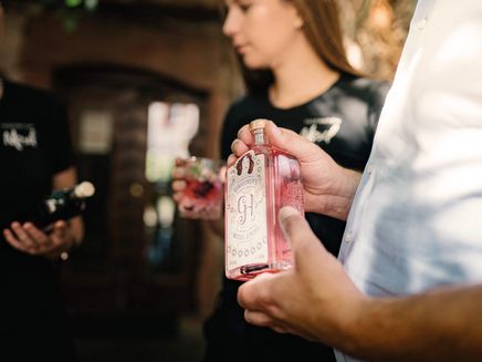 Gin von der Mosel © Simone Röhr Rosafarbene Fasche Gin in Hand einer Person