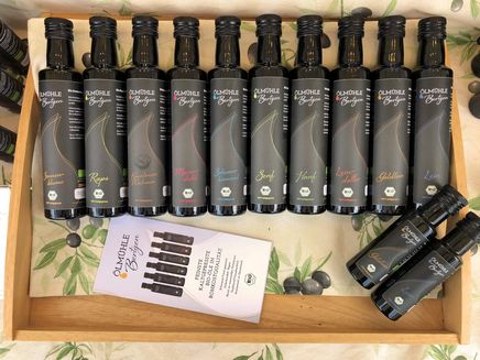 Koblenz, Produktvielfalt der Ölmühle Bertgen © Ölmühle Bertgen Schwarze Ölflaschen auf Holztablett liegend aufgereiht